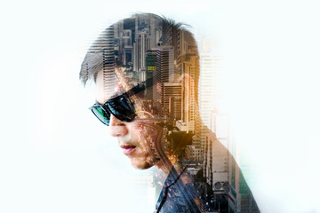 Smart business man is standing and wearing suit uniform. Double exposure on city landscape.