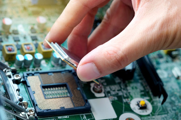 Hand of computer engineering brings computer cpu processor memory change components into socket...