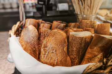 Loaves of fresh baked french bread in a basket at a bakery.