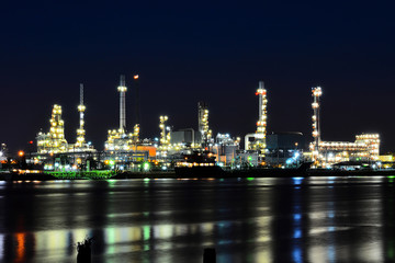Fototapeta na wymiar Oil and gas refinery plant area near the river at twilight, sunset time