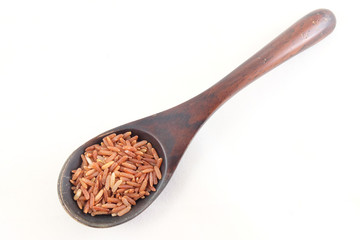 red rice in wooden spoon