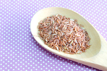 red rice in wooden spoon