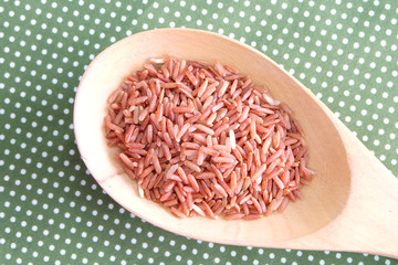 red rice in wooden spoon