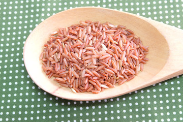 red rice in wooden spoon