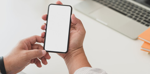 Close-up view of businessman surfing the internet on blank screen smartphone