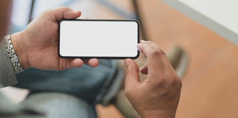 Cropped shot of professional businessman holding horizontal blank screen smartphone