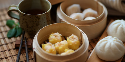 Cropped shot of Chinese steamed dumpling and steamed pork bun in a bamboo steamer