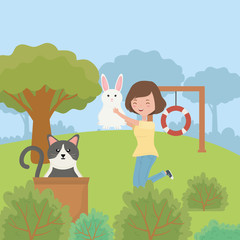 woman with rabbit and cat with box in the park pet care
