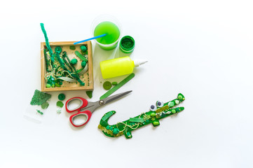 Craft cardboard crocodile. Decoration beads and buttons.