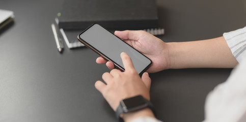 Close-up view of young professional businesswoman holding blank screen smartphone