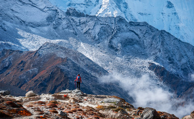 Active hiker hiking, enjoying the view, looking at Himalaya mountains landscape. Travel sport lifestyle concept