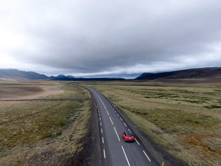 Red Car Driving On Country Road In Iceland