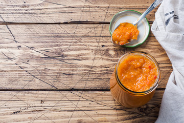 Homemade caviar from zucchini tomatoes and onions in a glass jar on a wooden background. Homemade production canning, canned stewed vegetable.