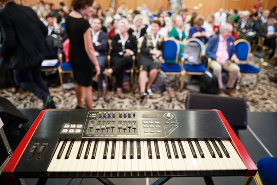 Shallow depth of field image with an electronic musical keyboard on stage during a conference