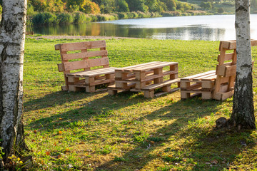 Rustic wooden table and benches at a lake