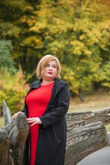 Plus size middle age woman in classical look at park, fashionable style for plump ladies 