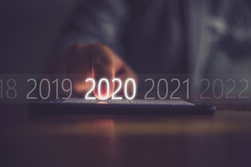 Business men press numbers 2020 at the mobile phone screen .Concept welcome merry christmas and...