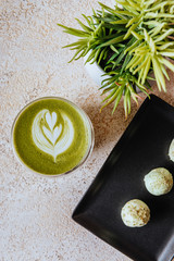 hot mocha green tea latte with candies on light texture background