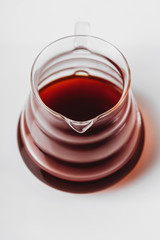 Transparent glass teapot with tea or coffee on white background