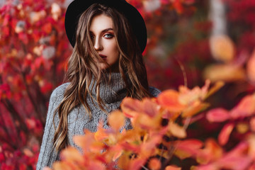 Fashion woman on a background of red and yellow autumn leaves