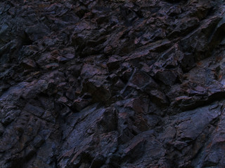 Black rock texture. Dark blue stone grunge background. Mountain close-up. Crashed. Background with space for design.