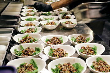a catering for a restaurant with a lot of plates with lettuce