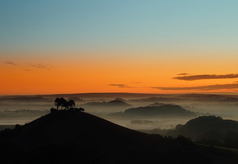 Obraz premium Misty morning over Collmer's Hill in the Dorset Area of Outstanding Natural Beauty (AONB).