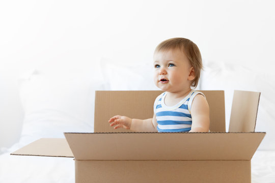 Cute baby boy sitting in delivery box