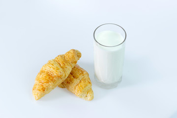 a glass of milk and bread isolated on white background selective focus at croissant bread