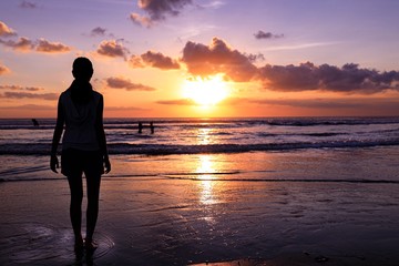 Siluette of a human on the beach holding a flag