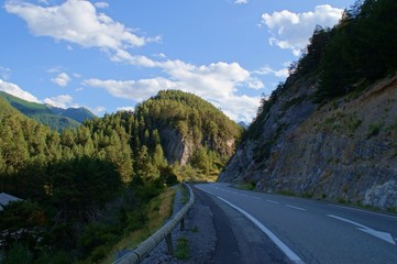 curly road on the mountain Forest through narrow val in french alps, France