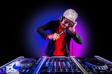 Glamorous Dj singing in microphone and playing on the turntable at night club. Club, nightlife.