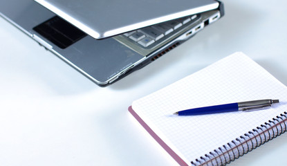 Laptop with stack of folders on table on white background