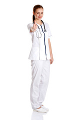 Smiling medical doctor woman or nurse standing on white background with thumb up.