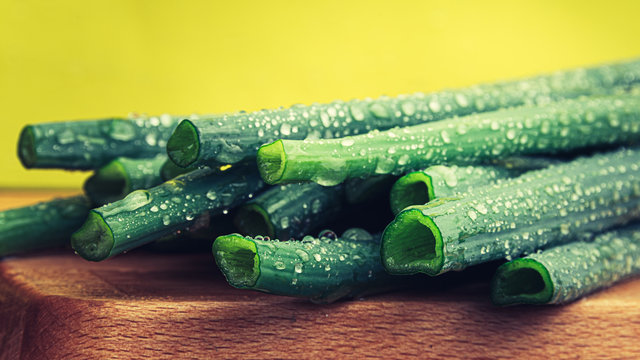 Green onions on wooden table. Bunch of onions batun ready for cooking. Healthy eating and vegetarianism.