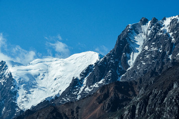 Fototapeta na wymiar Snow cliffs under blue sky. Travel in mountains