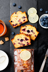 Homemade Blueberry Lemon Cake on black stone background.