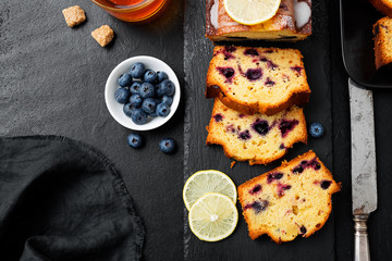 Homemade Blueberry Lemon Cake on black stone background.