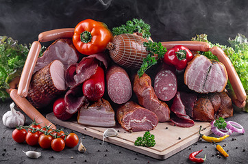 smoked meat and sausages in assortment with herbs and spices