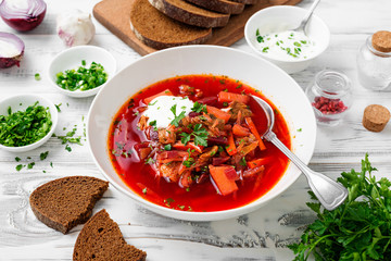 Beetroot soup - Traditional Ukrainian or Russian borscht with sour cream in a white bowl.