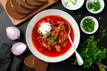 Beetroot soup - Traditional Ukrainian or Russian borscht with sour cream in a white bowl.