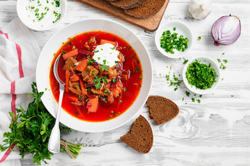 Beetroot soup - Traditional Ukrainian or Russian borscht with sour cream in a white bowl.