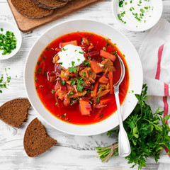 Beetroot soup - Traditional Ukrainian or Russian borscht with sour cream in a white bowl.
