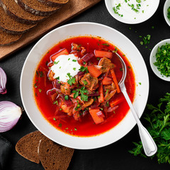 Beetroot soup - Traditional Ukrainian or Russian borscht with sour cream in a white bowl.
