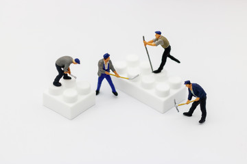 Miniature people: Worker digging white box. Service,  repair and  maintenance concept.