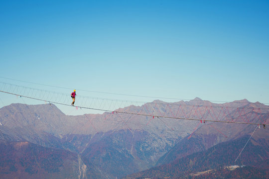 View of the mountain landscape gorge, tourist man walking along an extreme staircase over a precipice.