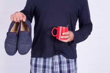 man with coffee cup and house slippers