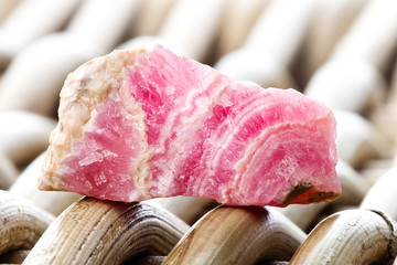 Macro photography of a rhodocrosite stone on a wicker background