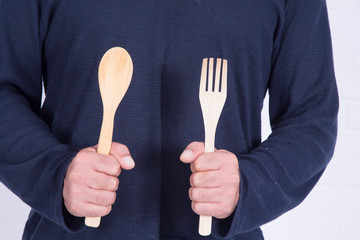 man holding spoon and fork ready to cook