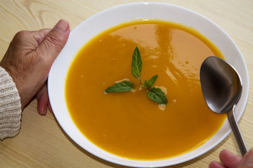 woman holding bowl of vegetable soup
